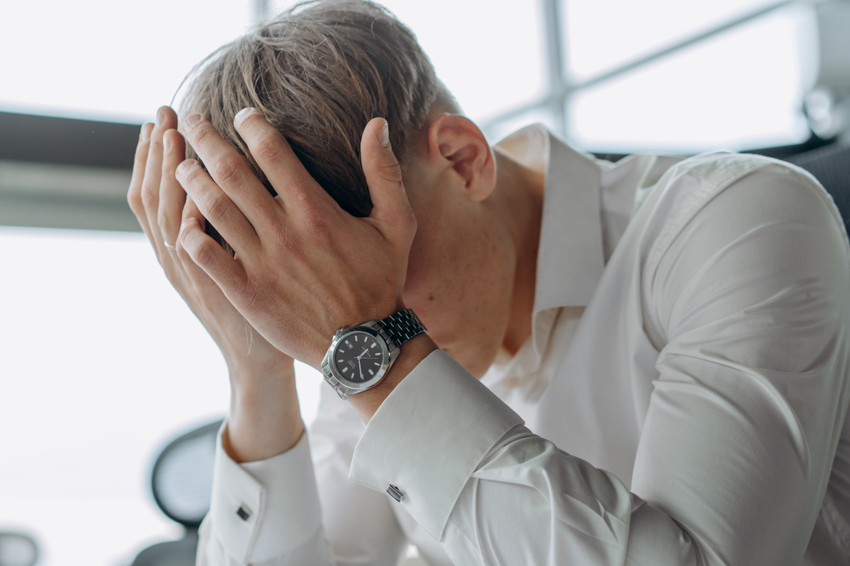 A Man Places His Hands on His Head 